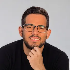 Rainier Ramos, fundador de KRONEX LABS, sonriendo con gafas y jersey negro